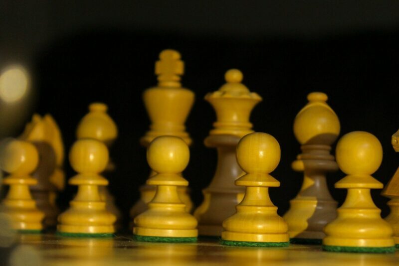 yellow chess pieces on brown wooden chess piece